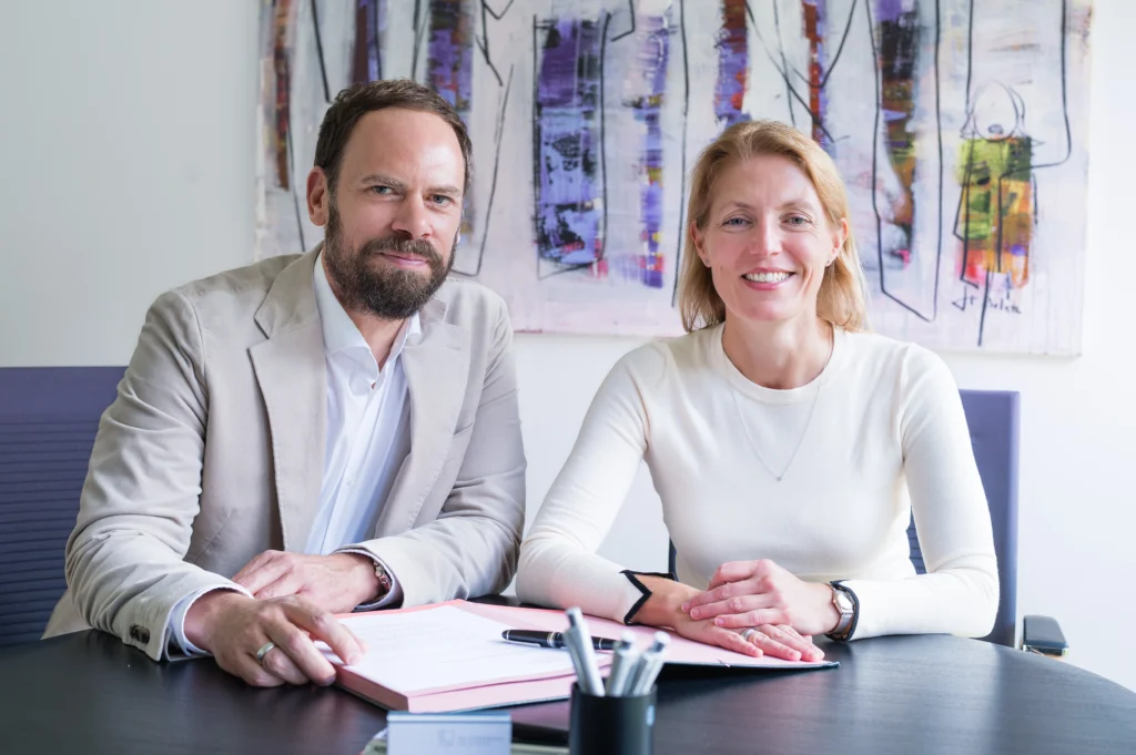 Miriam und Dr. Ioannis Lymperidis an einem Besprechungstisch